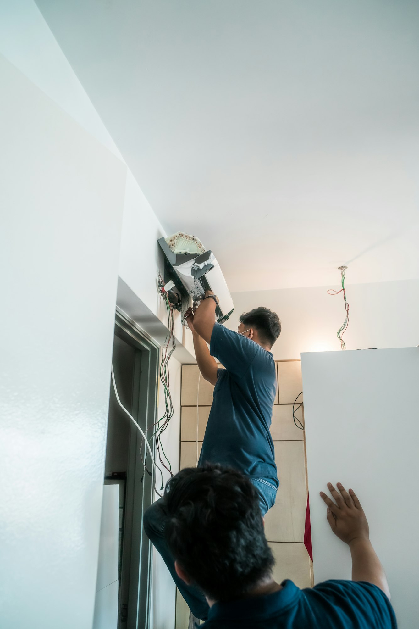 Technician repairing air conditioner on the wall
